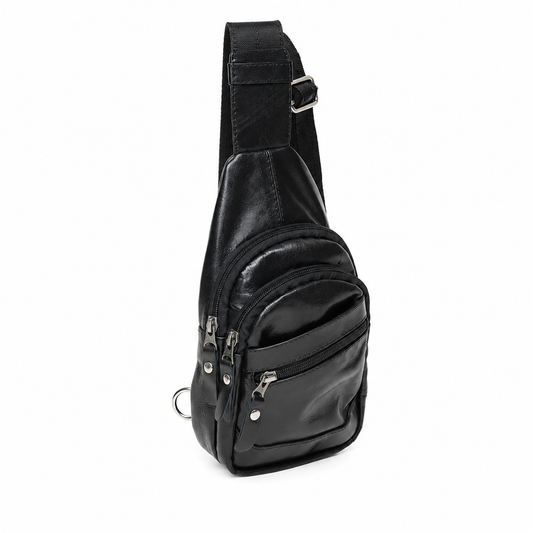A black faux-leather sling bag with a wide adjustable shoulder strap, a front zippered pocket, and a lower zippered compartment, shown on a plain white background.