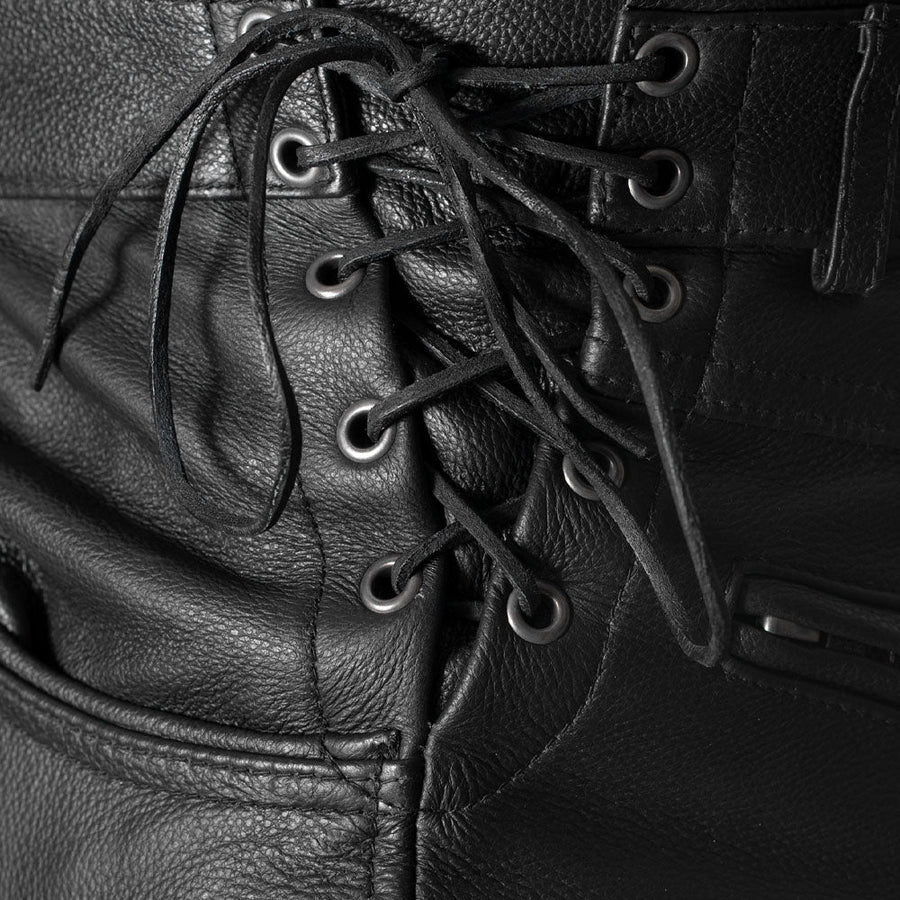 Close-up detail of a black leather lace-up with black laces threaded through dark metal eyelets.