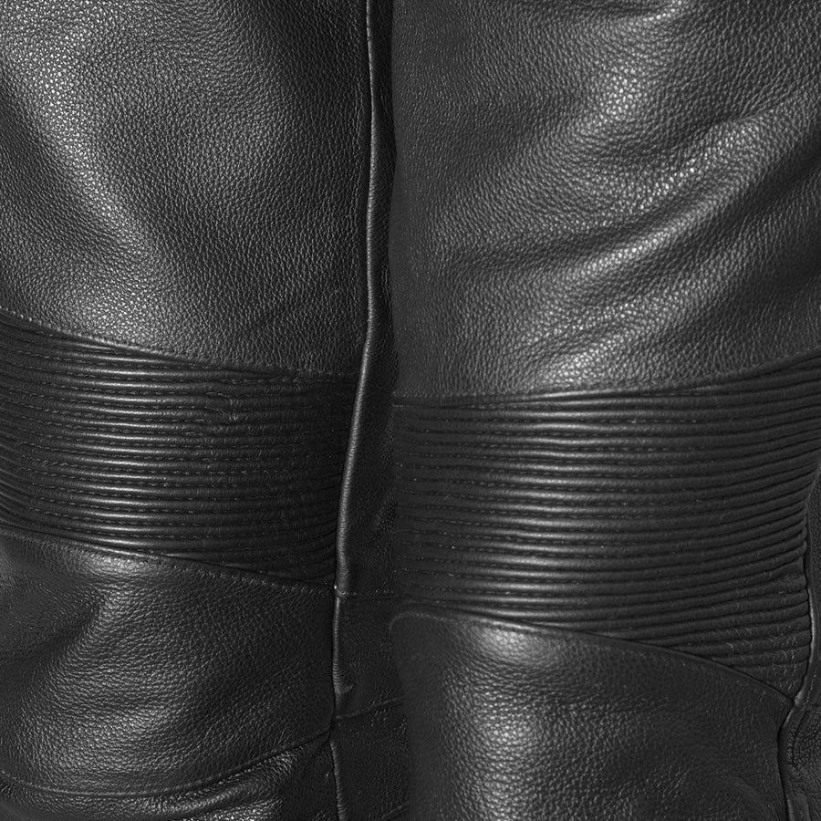 Close-up of black leather pants showing the back seam, pebbled texture, and horizontal ribbed paneling.