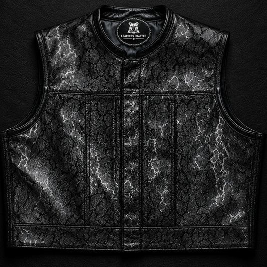 A black leather motorcycle vest with a textured, cracked pattern and a central zipper, displayed flat against a dark textured background with a 'LEATHERS CRAFTED' logo at the top.