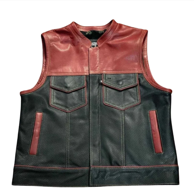 A leather motorcycle vest with a two-tone design, featuring a reddish-brown leather yoke and upper chest with red contrast stitching, and a black perforated leather body with matching red stitching and pocket details.